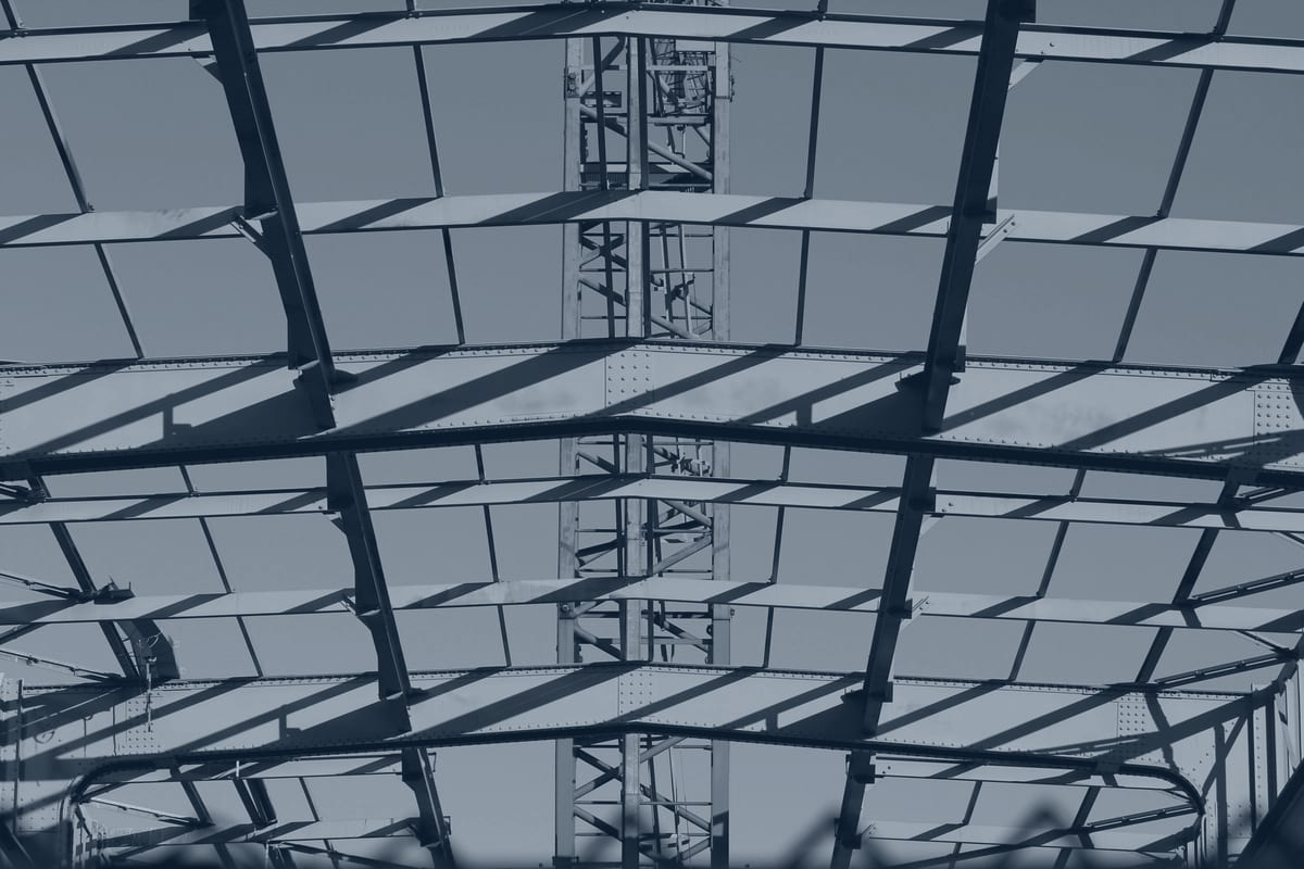High-bay steel structure interior with repeating columns and long-span framing.