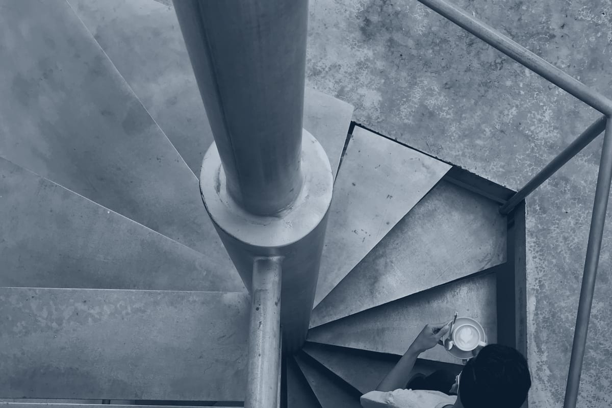 Fabricated steel feature staircase in an upscale interior, finish-exposed hospitality metalwork.