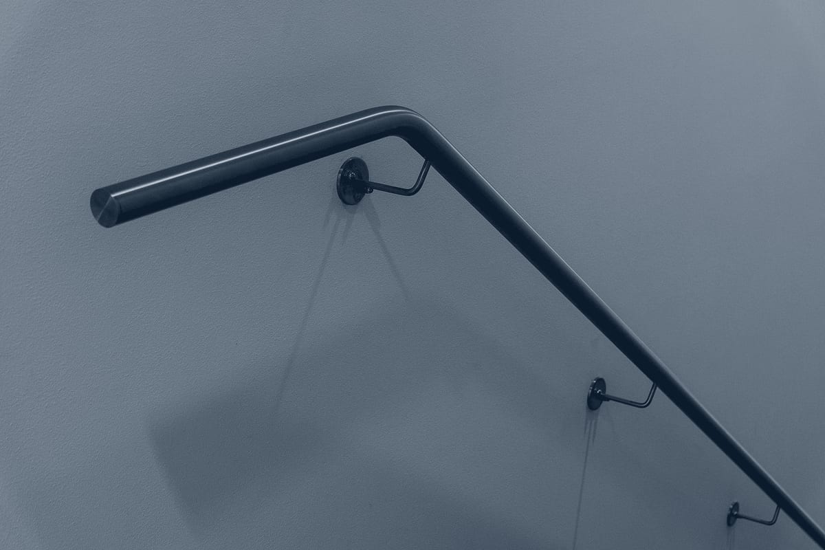 Stainless steel handrail with mounting brackets, a miscellaneous-metals fabrication detail.