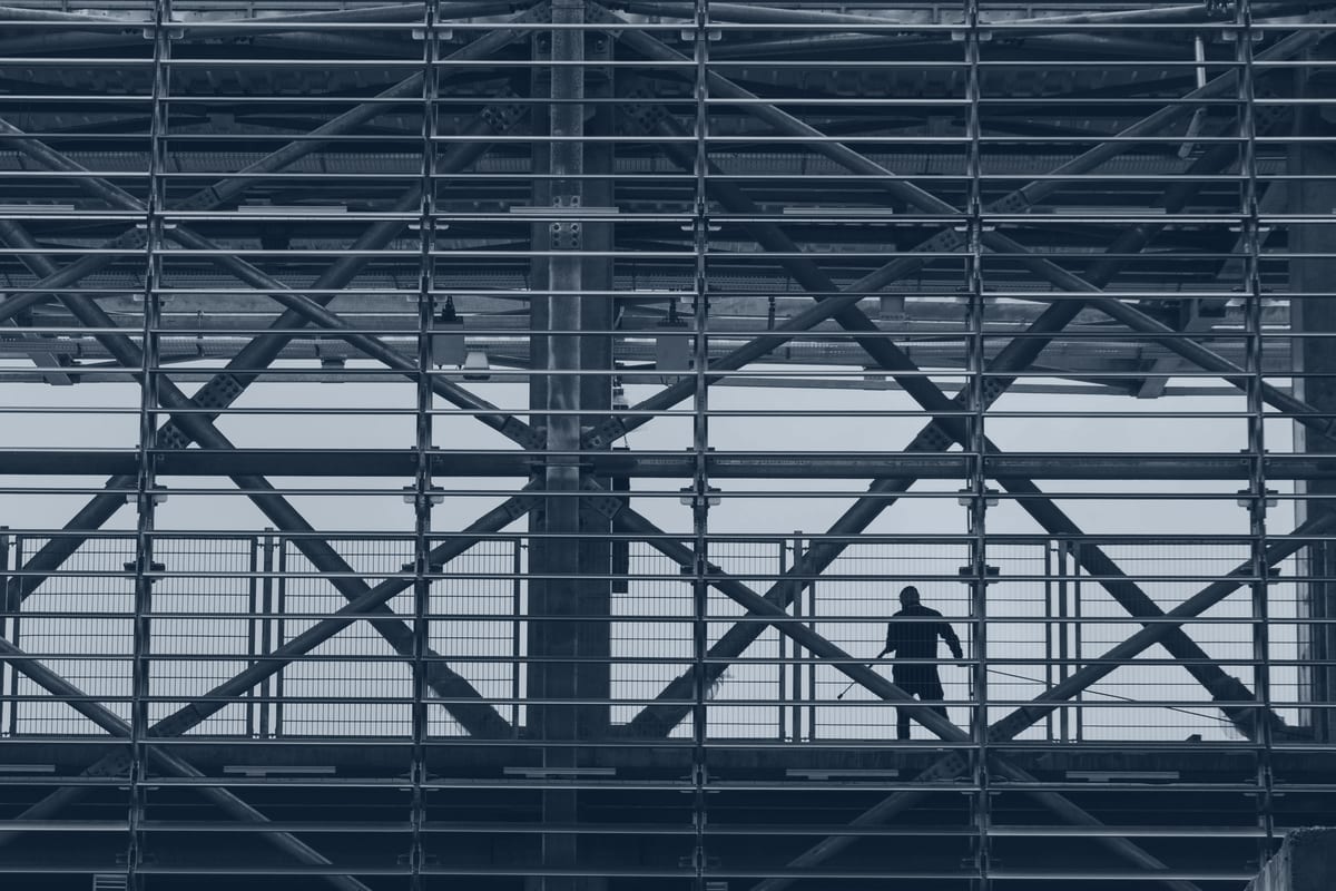 Fall-protection harness clipped to a steel member at height.